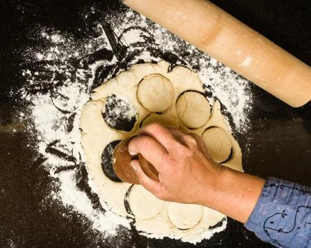 Cutting biscuits from rolled dough Stock Photos