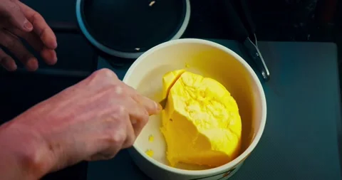 Cutting a bit of butter with knife Stockbeeldmateriaal 167431599