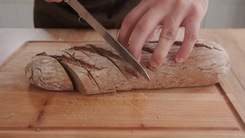 Cutting black bread on a table prepared for lunch Stock Footage 125930292
