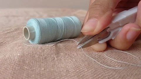 Cutting a blue thread with a small scissor Stock Footage 146248636