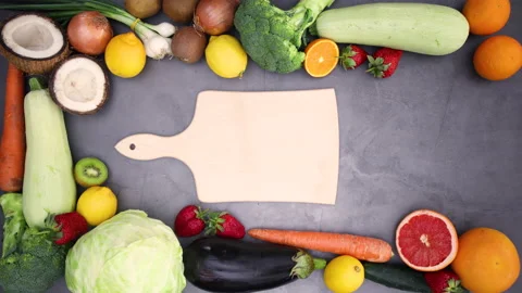 Cutting board appear inside of frame of fresh fruits and vegetables- Stop motion Stock Footage 130892387