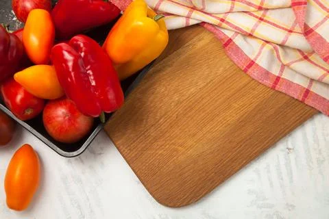 Cutting board with assort of different tomatoes and bell pepper on white wo.. Stock Photos