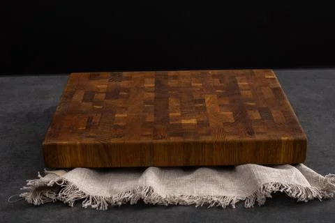 Cutting board on a grey stone table. Isolated on a black background. Culinary Stock Photos