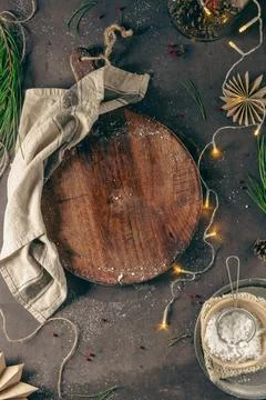 Cutting board on a kitchen table with Christmas decoration, sugar, paper st.. Stock Photos