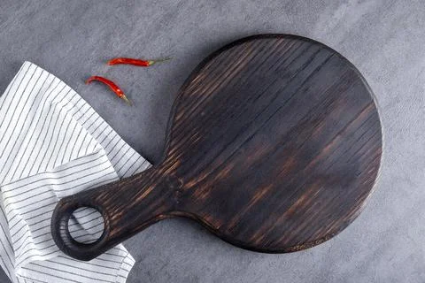 Cutting board or steak serving board with linen napkin and pepper Stock Photos