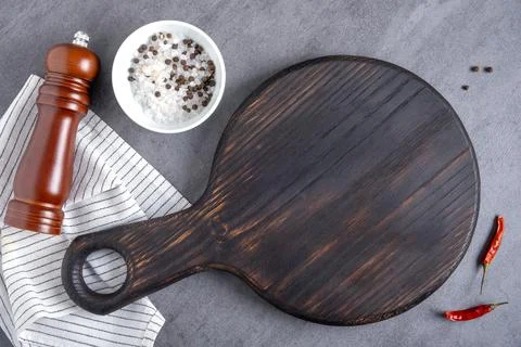 Cutting board or steak serving board with napkin and spice shaker Stock Photos