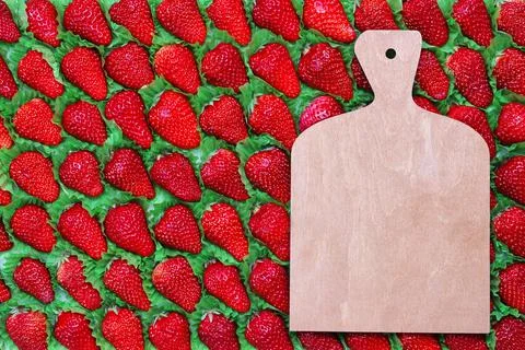 A cutting board with a place for text is placed on a strawberry Stock Photos