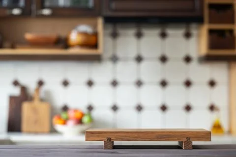 Cutting board on table over blurred home kitchen Stock Photos