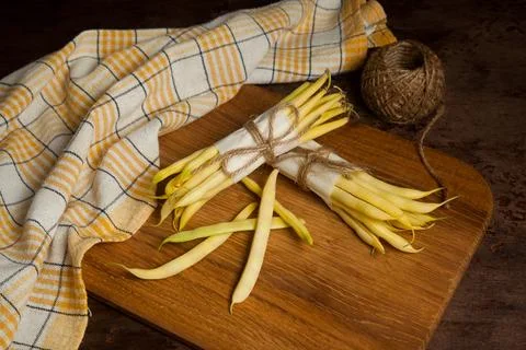 Cutting board with two bunch and several pods of flat runner bean pods heap.. Stock Photos