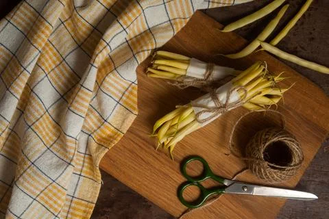 Cutting board with two bunch and several pods of flat runner bean pods heap.. Stock Photos