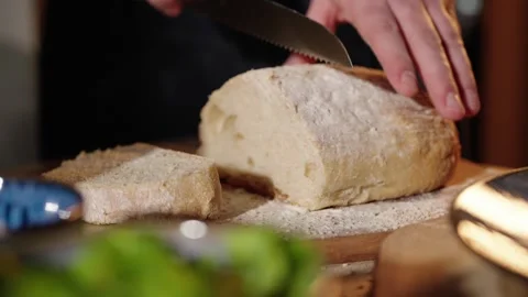 Cutting bread with breadknife in slow motion Stock Footage 254590077