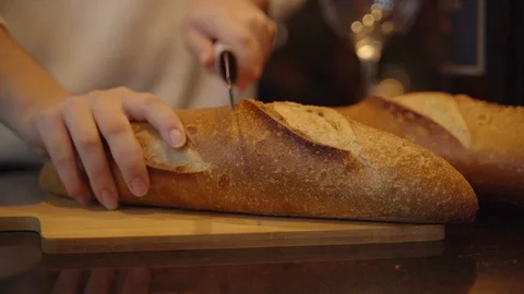 Cutting Bread Half over Wooden Board 스톡 동영상 112032610
