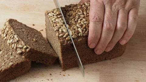 Cutting of bread with sunflower seeds Stock Footage 200946336