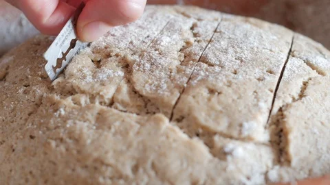 Cutting the bread surface with a razor blade before baking Stock-Footage 88424373