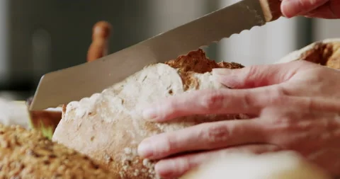 Cutting bread on a wooden table  4K. Stock Footage 221570231