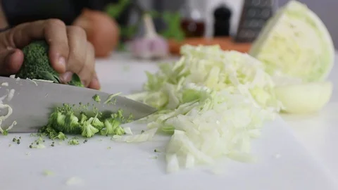 Cutting Broccoli over a white board Stock Footage 129044411