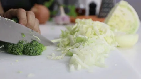 Cutting Broccoli over a white board with a professional knife. Stock Footage 129249045