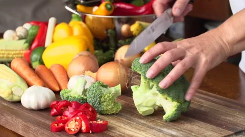 Cutting broccoli with vegetables in the background Video stock 51184793