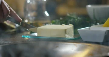 Cutting the butter to put it in the pan 4k Stock Footage 85836064
