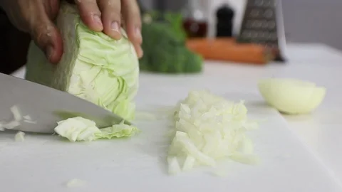 Cutting Cabbage over a white board with a professional knife. Stock Footage 129044442