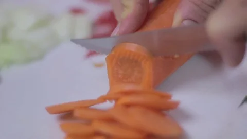 Cutting a carrot into slices with a sharp knive Stock Footage 75612369