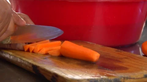 Cutting Carrots into slices on a cutting board Stock Footage 156765415