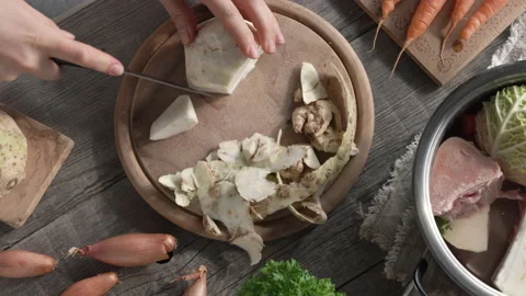 Cutting celery root in order to prepare homemade bone broth or soup Video stock 171991474
