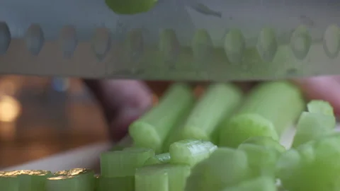 Cutting celery using kitchen knife on wooden board, Fresh healthy celery for Stock Footage 148692945
