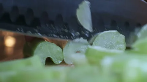 Cutting celery using kitchen knife on wooden board, Fresh healthy celery for Stock-Footage 165773142