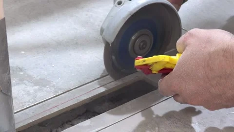 Cutting ceramic tile with an angle grinder and diamond blade along a marked.. Stock Footage 340556007