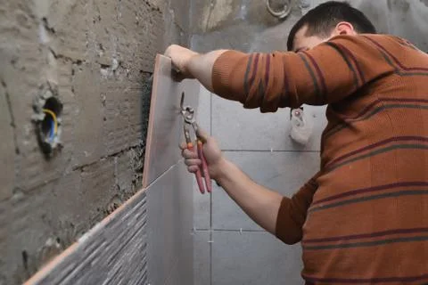 Cutting ceramic tiles manually. Opening a hole in the tile. Stock Photos