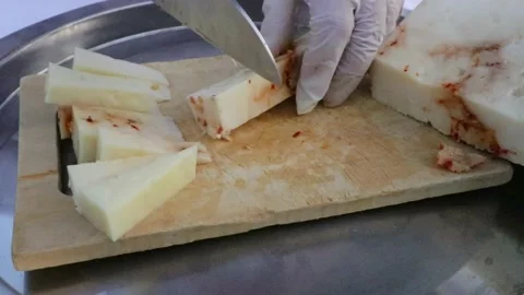 Cutting cheese with a knife in cubes 4k 60fps Stock Footage 156624178