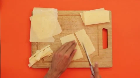 Cutting cheese on orange background 001 Stock Footage 242958959