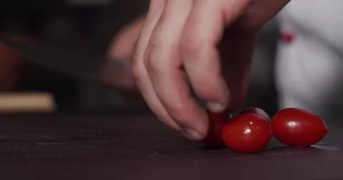 Cutting of cherry tomatoes with the kitchen knife, 4k Stock Footage 136355899