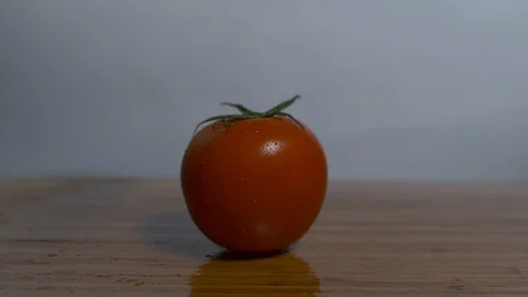 Cutting cherry tomatoes with a knife on a chopping board in slow motion Stock Footage 100006272