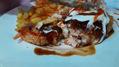 Is cutting a chicken burger with cutlery Stock Footage 308229204