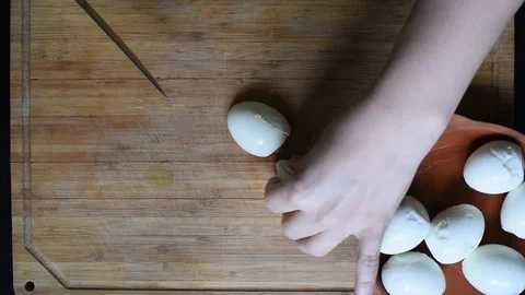 Cutting chicken eggs with a knife into small cubes on a wooden table Stock Footage 96058531