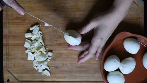 Cutting chicken eggs with a knife into small cubes on a wooden table Stock Footage 96058560
