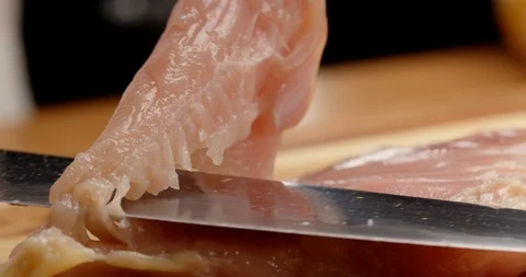 Cutting chicken fillets with chef knife close up Видео 126257675