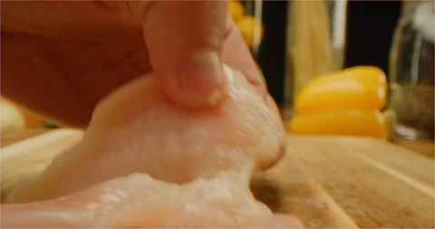 Cutting chicken fillets with chef knife macro shot Stockbeeldmateriaal 126289329
