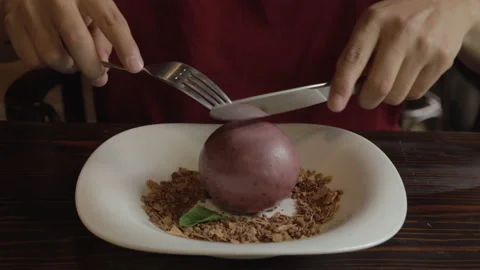 Cutting a chocolate-covered round cheesecake with a fork and knife Stock Footage 156841226