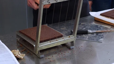 Cutting the chocolates by confectionery strings Stock Footage 127290575