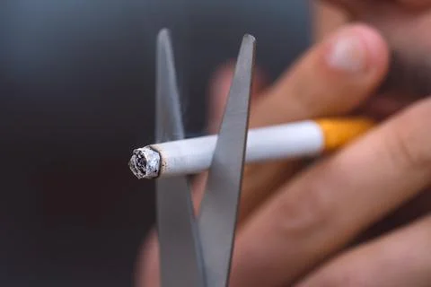 Cutting cigarette with scissors. Stop smoking, quit smoking, no smoking concept Stock Photos