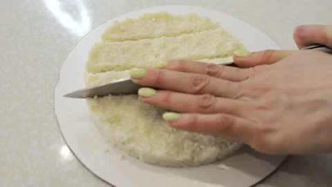 Cutting a coconut dessert into pieces with a knife Stock Footage 130231053
