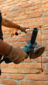 Cutting a contour to make a window opening in a brick wall Stock Photos
