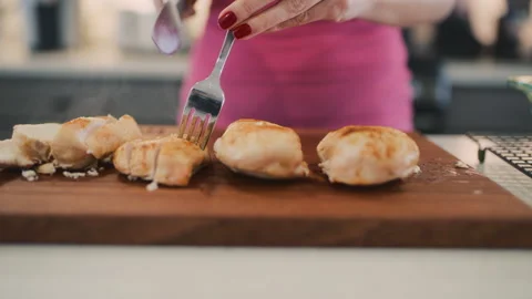 Cutting cooked chicken in the kitchen for meal preparation and serving Stock Footage 310241926