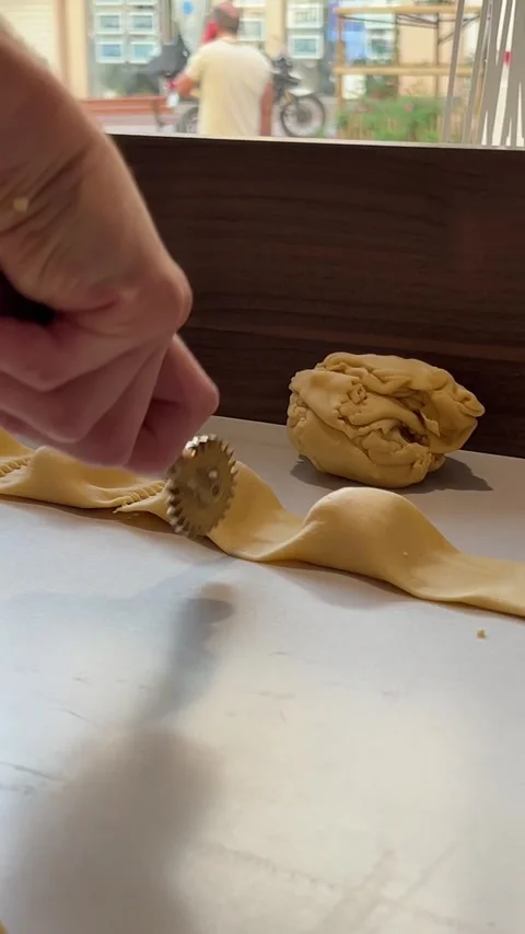Cutting cooked ravioli near the window male hands Chef production pasta Italian Stock Footage 302803059