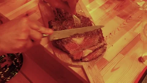Cutting cooked roast beef in thin slices on a wood cutting board Stock Footage 212242270