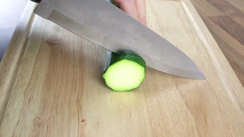 Cutting A Courgette On A Wooden Chopping Board With A Large Kitchen Knife 스톡 동영상 134934412