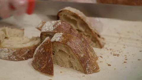 Cutting crusty bread slices on a cutting board for a meal. Stock Footage 331914448